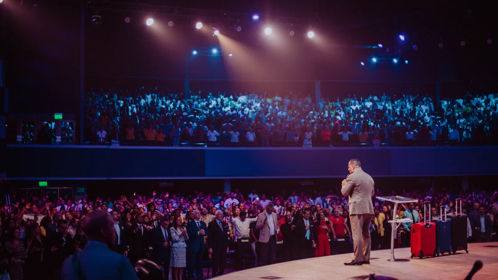 Pastor speaking from a church stage to a large congregation